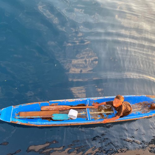 Besuch von einem jungen Souvenirverkäufer bei einer Bootstour im Komodo Nationalpark